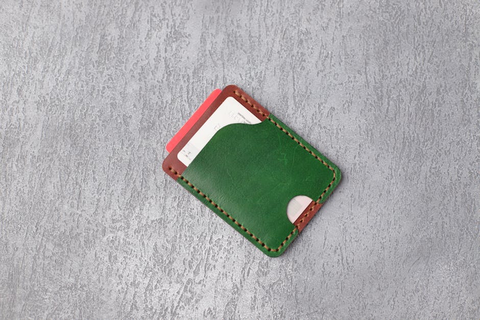 Stylish green leather wallet on textured gray surface showcasing minimalistic design.