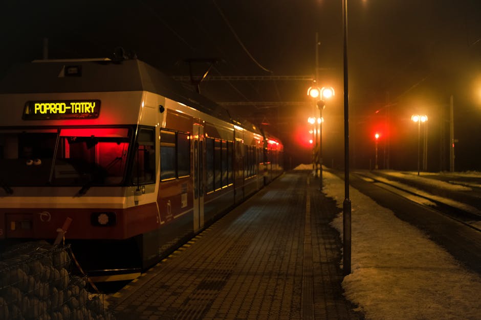 Moody night scene of train at Poprad-Tatry station under winter lights.